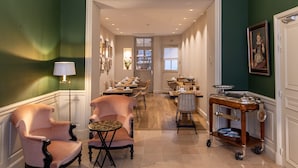 A hotel lobby with a long corridor leading to a dining area, featuring classic furniture and a decorative cart. - Hotel du Danube Saint Germain (Paris)
