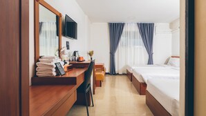 Ett hotellrum med ett skrivbord i trä, en stol, en säng och en tv som är monterad på väggen.