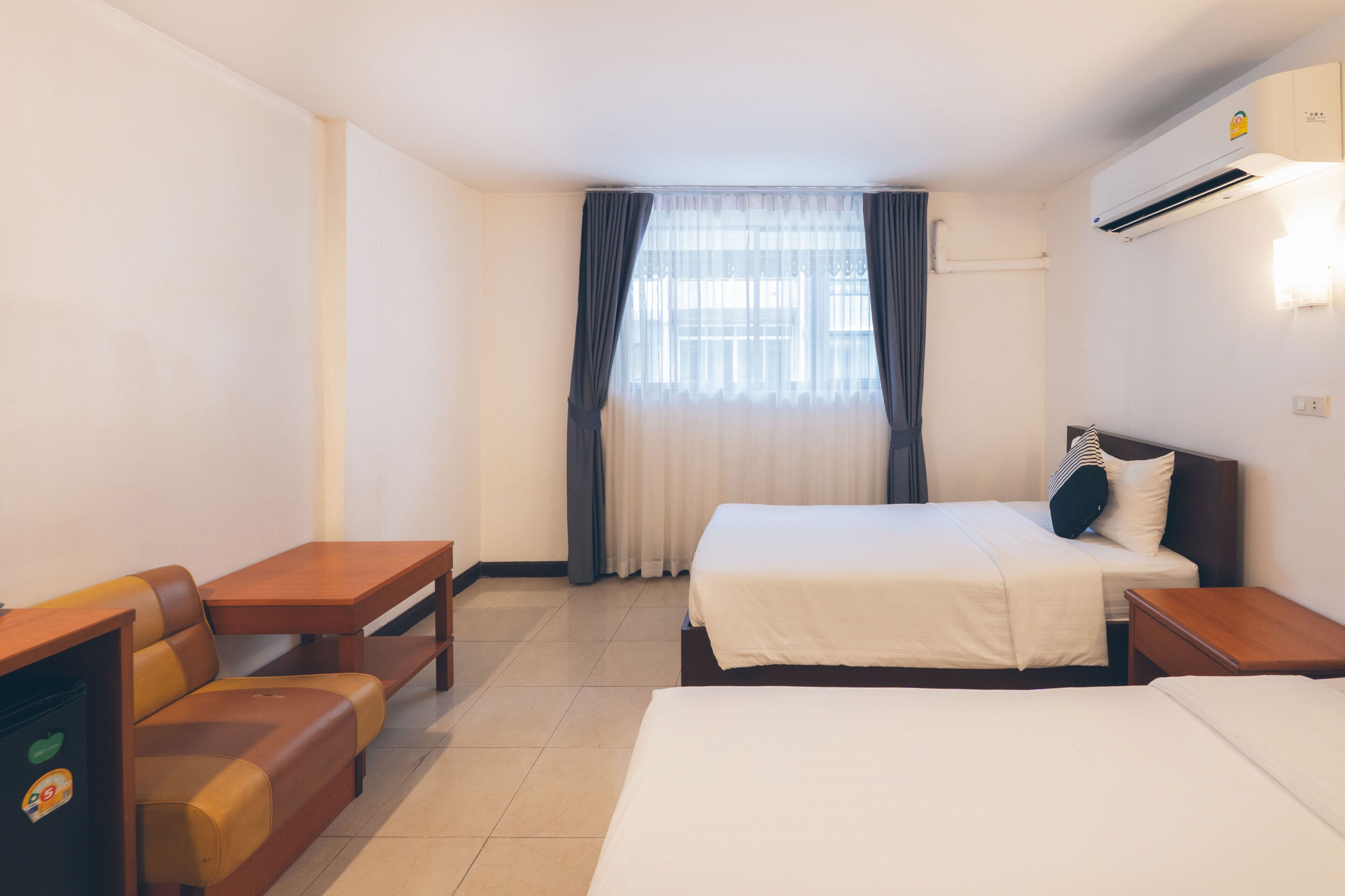 A hotel room with a bed, a sofa, a desk, and a TV.