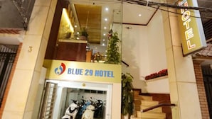 El exterior del Hotel Blue 29, con una entrada visible, una escalera que conduce al piso superior y un letrero que indica el nombre del hotel.