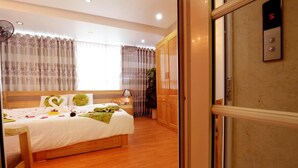 Una habitación de hotel con cama, mesita de noche, lámpara y armario.