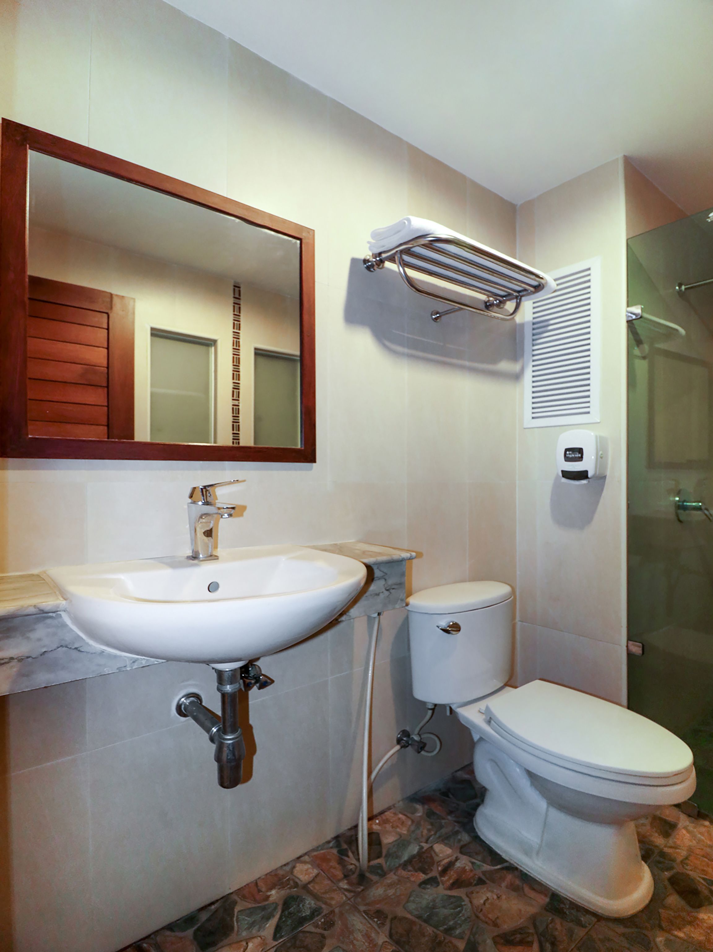 Un baño con lavamanos, inodoro y ducha.
