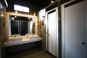 A bathroom with two sinks, a large mirror, and a door. - A7 Hidden Hostel (Bangkok)