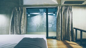 A bedroom with a bed, a window with curtains, and an air conditioning unit.