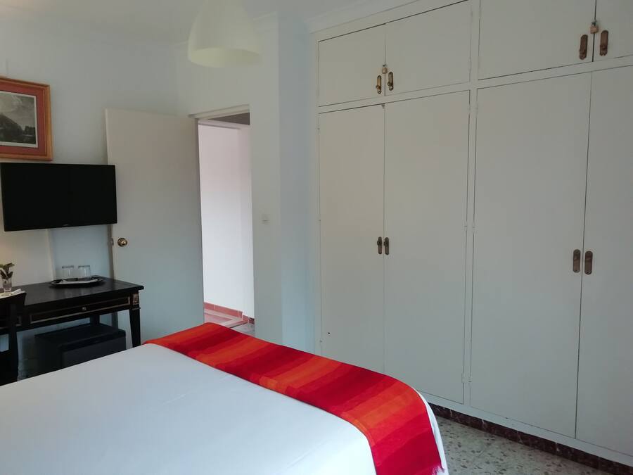A room with a bed, a desk, a television, and a wardrobe.