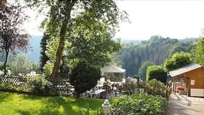 A garden with a gazebo, a pathway, and a building with a sloped roof. - SPA Hôtel Au Lion D'Or (La Petite-Pierre)