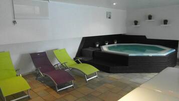 Relax in a serene space with a hot tub and two lounge chairs.