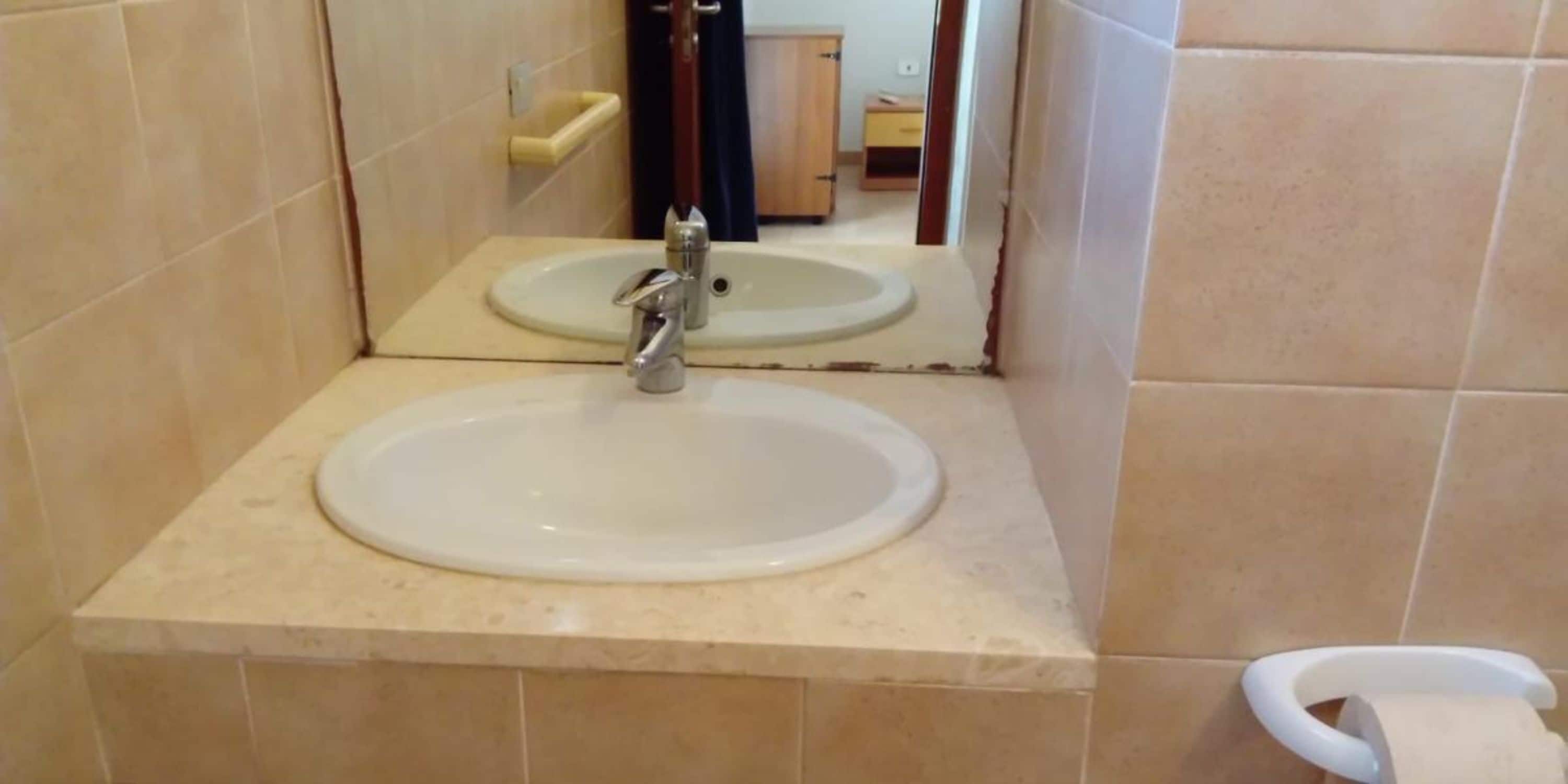 A bathroom with a sink, mirror, and toilet.