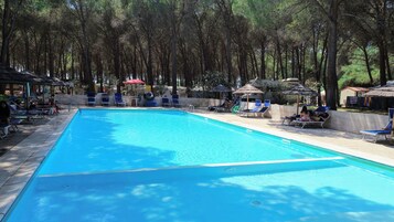 Una piscina al aire libre de temporada, sombrillas