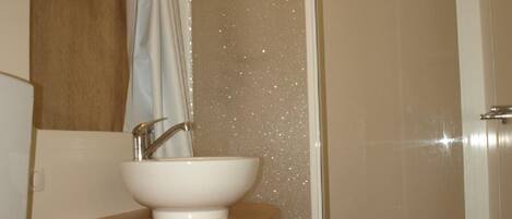 A bathroom with a white sink, a mirror, and a shower curtain.