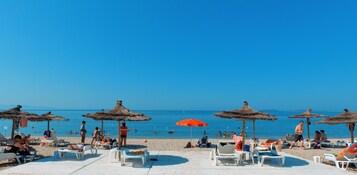 Playa privada, sillas reclinables de playa, sombrillas