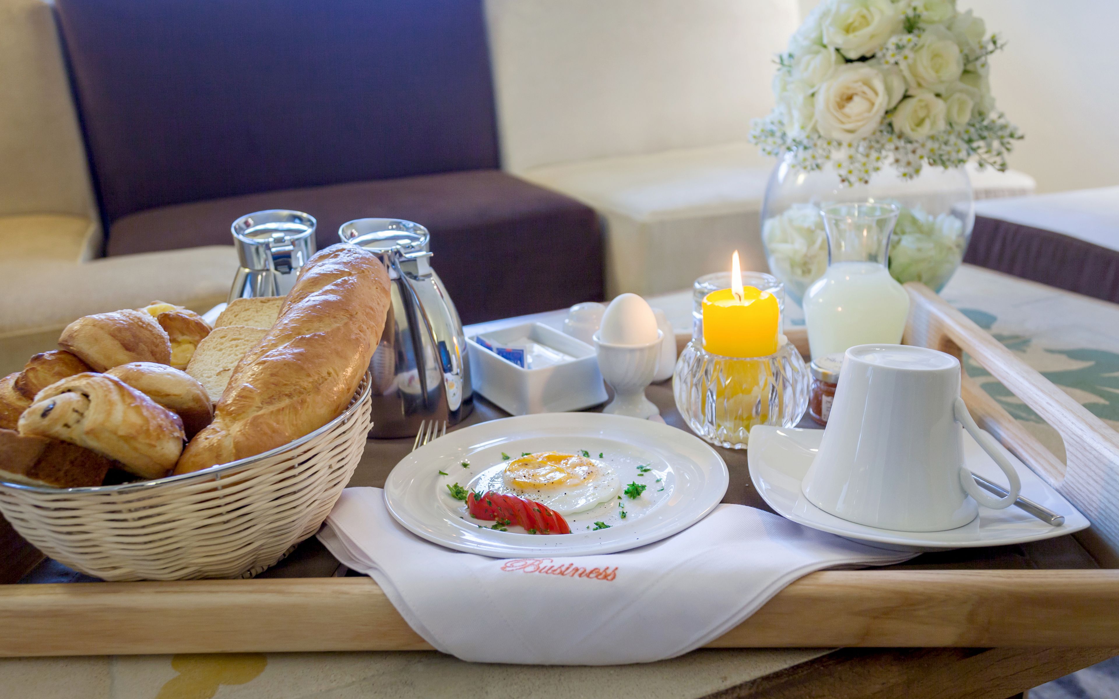 Un plateau de petit-déjeuner avec du pain, des œufs et une bougie.