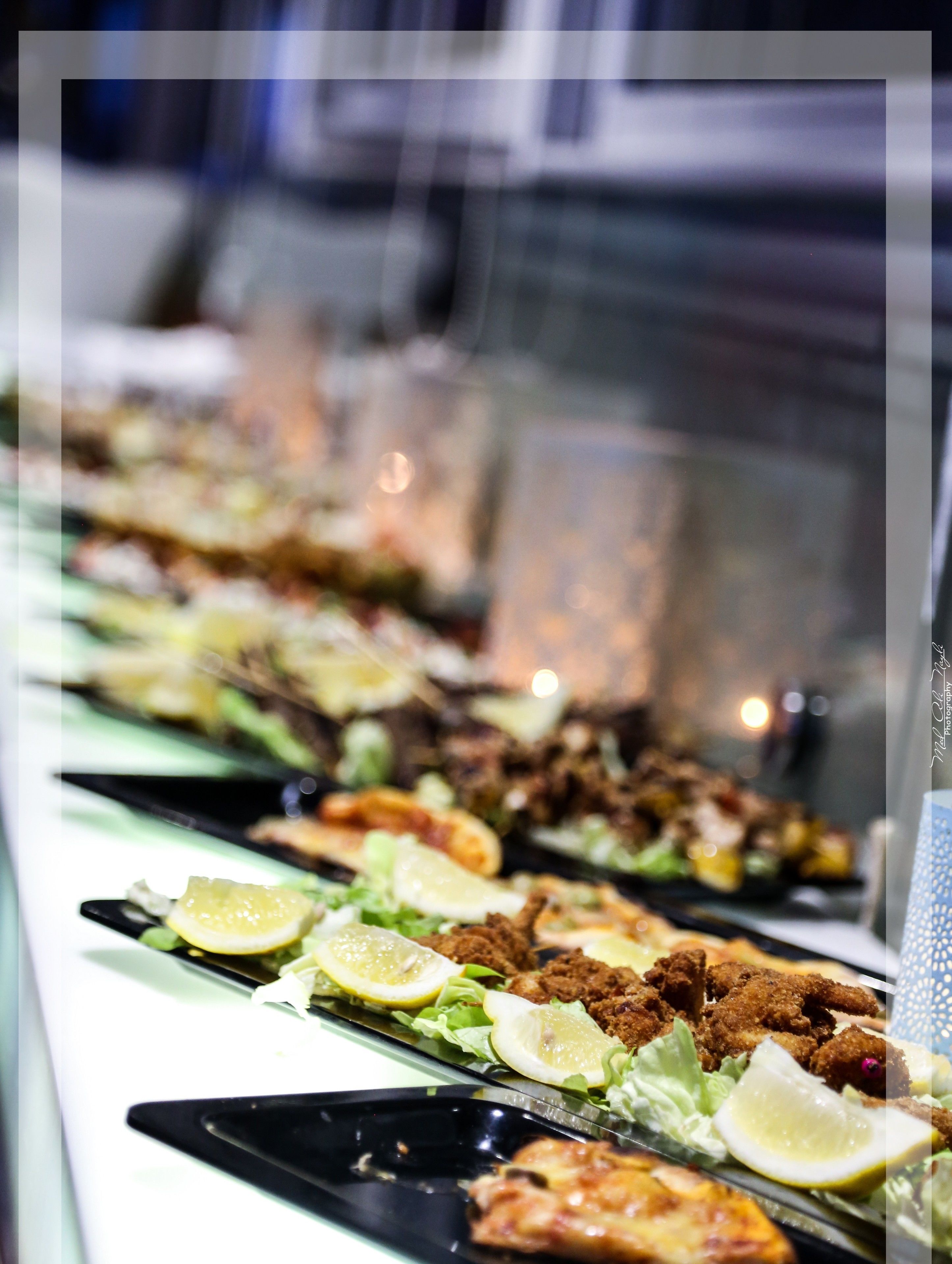 A buffet with various dishes, including fried items and salads, arranged on black plates.