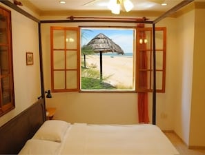 A bedroom with a bed, a window with a view of a beach and a thatched umbrella, and wooden-framed windows. - River Ray Estates (Ho Chi Minh City)