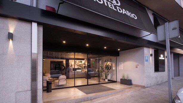 A modern hotel entrance with a glass facade, a reception desk, and a seating area with sofas. - U-Hotel Dario Lugo (Lugo)