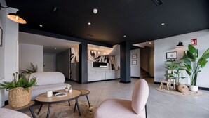 A modern hotel lobby with a reception desk, seating area, and large potted plants. - U-Hotel Dario Lugo (Lugo)