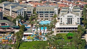 An aerial view of a resort with a beach, a pier, and a pool area. - DOBEDAN BEACH RESORT COMFORT (Manavgat)