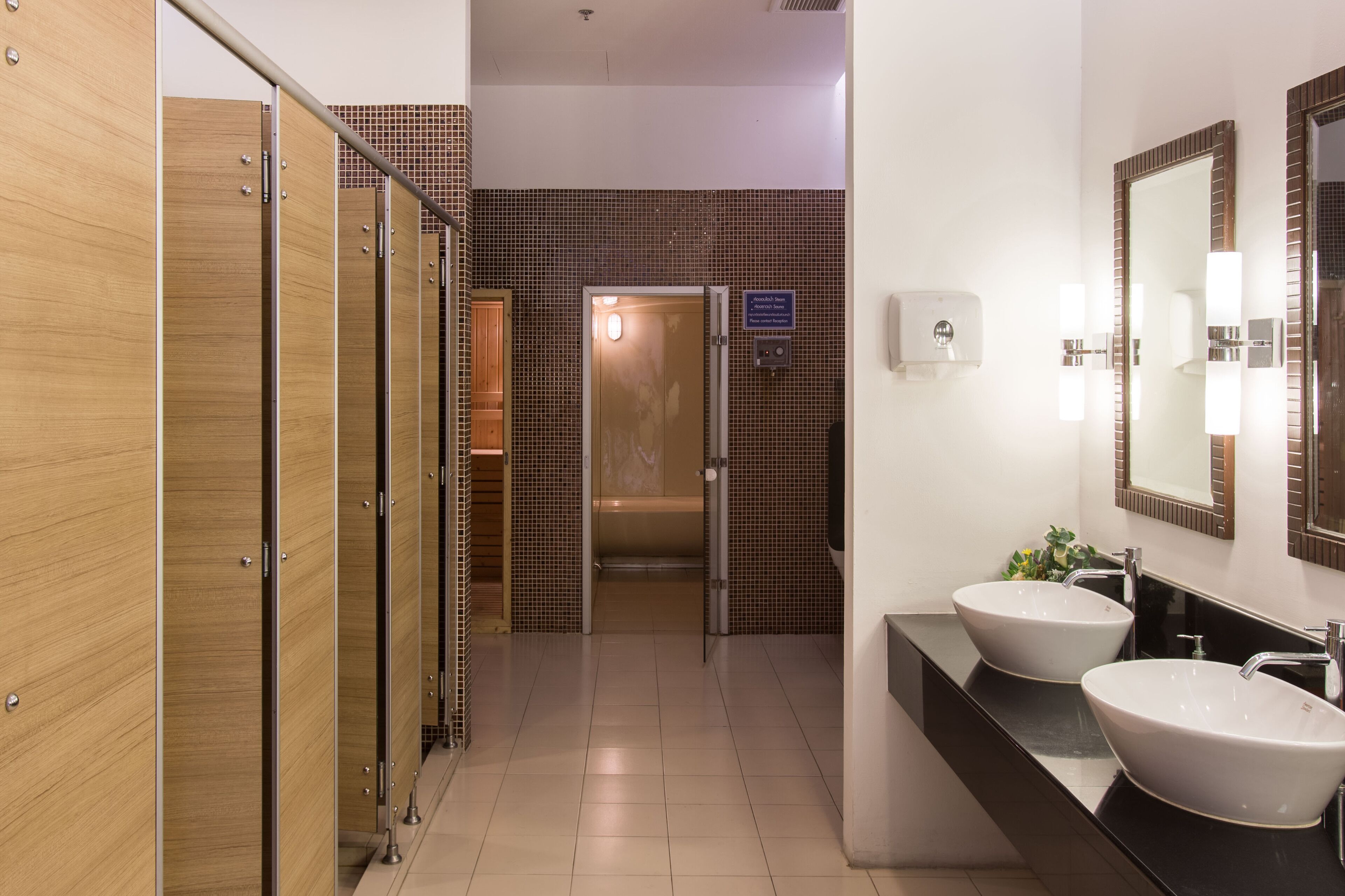 A modern bathroom with two sinks, a mirror, and a shower area.