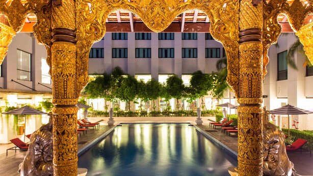 An ornate pool area with golden pillars and a clear view of a building in the background. - Mida Grande Hotel Dhavaravati, Nakhon Pathom (Nakhon Pathom)