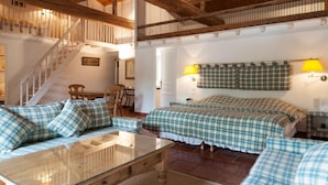 A cozy room with a wooden ceiling, a bed with plaid bedding, a glass table, and a staircase. - Domaine d'Auriac (Carcassonne)