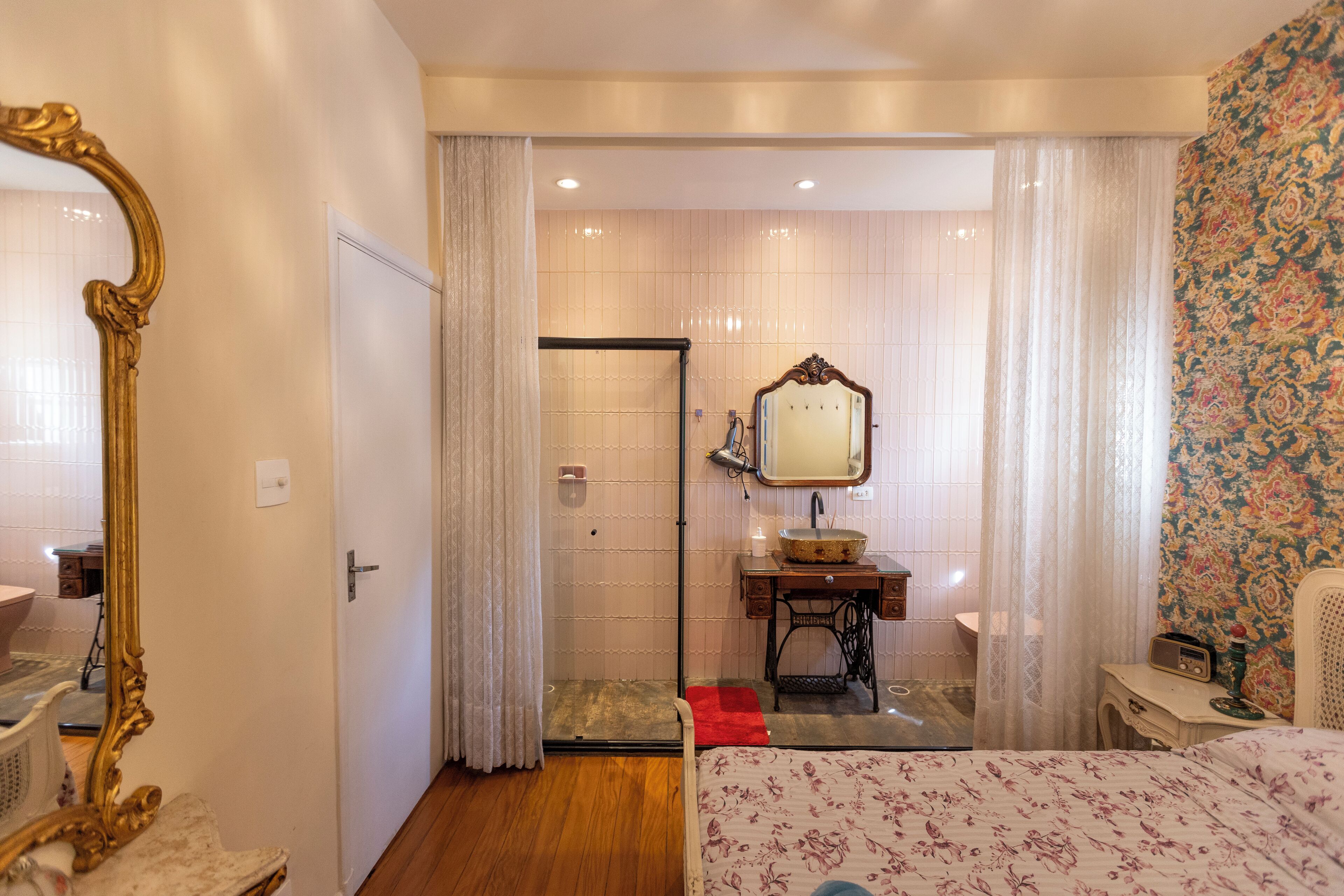 Une chambre d’hôtel avec un lit, une salle de bain comprenant un lavabo et un miroir, ainsi qu’une douche.