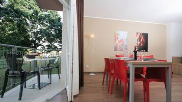 Un comedor con una mesa dispuesta para dos, sillas rojas y vistas al exterior.