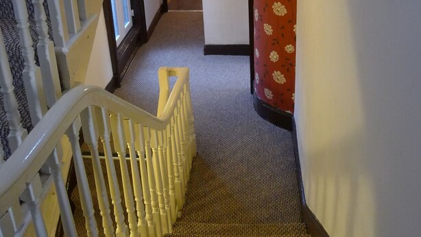 A staircase with white balusters leading to a landing. - Lagan Backpackers (Belfast)