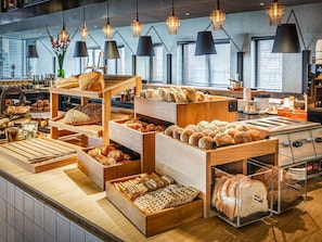 Una vitrina de panadería con panes y pasteles varios.