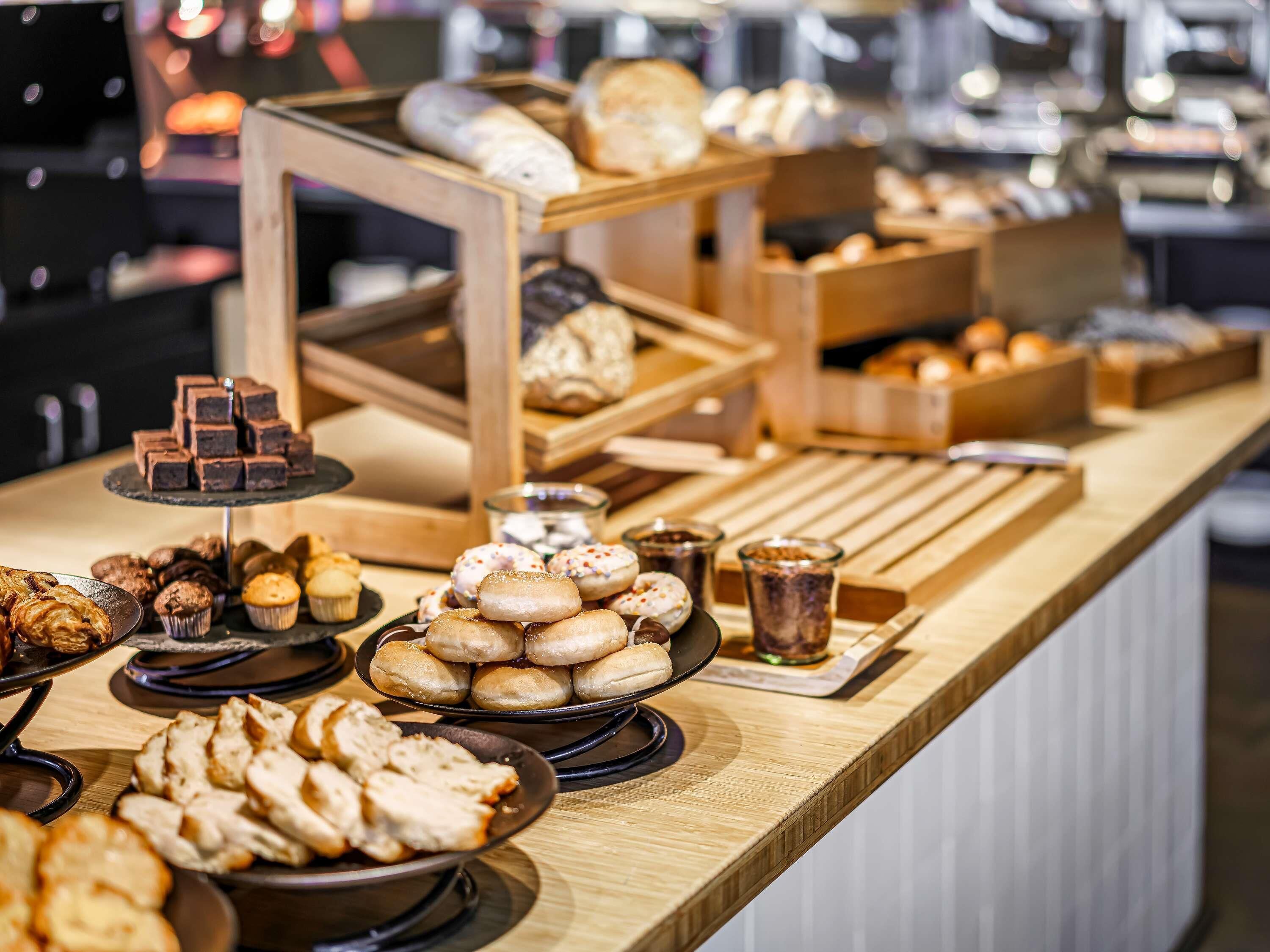 Un bufé con diversos productos de panadería y pastelería.