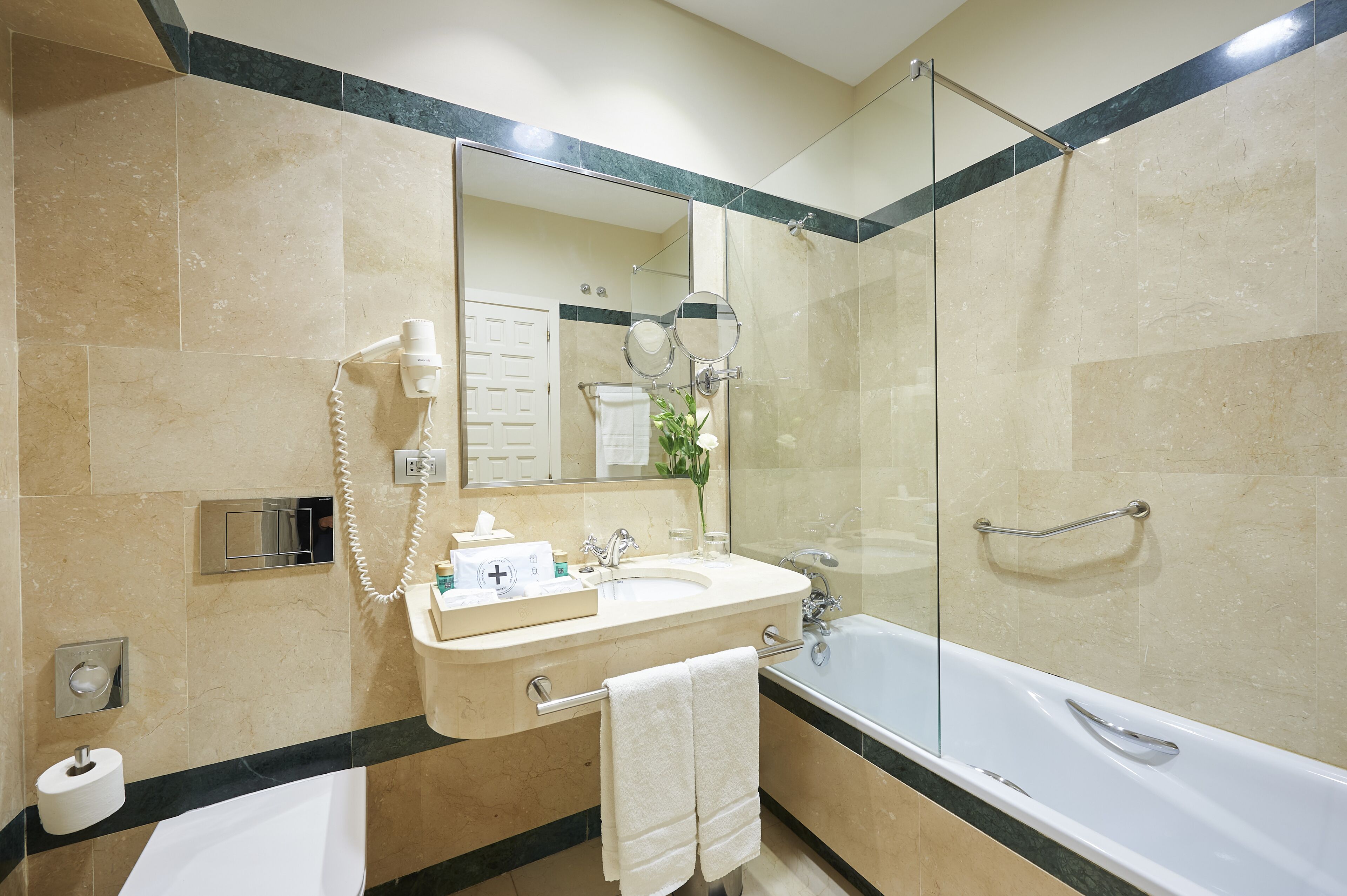 A modern bathroom with a glass-enclosed shower, a vanity with a mirror, and a bathtub.