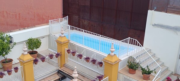 Una piscina al aire libre, sombrillas, tumbonas