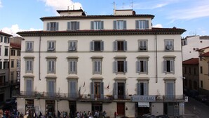 A multi-story hotel with a classic European architectural style, featuring a central entrance with a red door, multiple balconies, and a sign indicating it is the "HOTEL ARGENTINA". - Hotel Argentina (Florence)