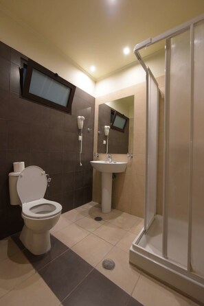A bathroom with a toilet, sink, and shower. - Santa Helena Hotel Ialysos (Rhodes)