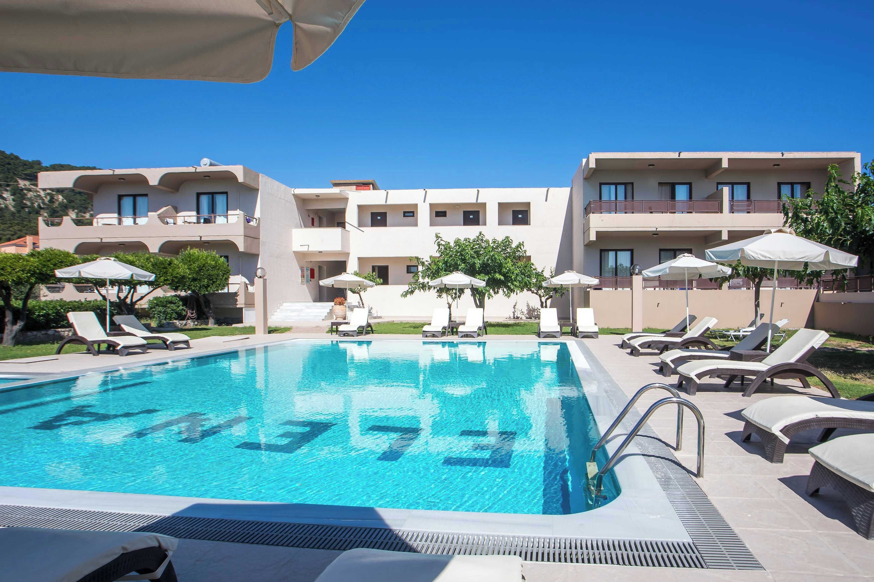Una piscina al aire libre, sombrillas, sillones reclinables de piscina