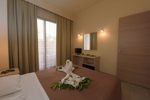 A hotel room with a bed, a desk, a television, and a wardrobe. - Santa Helena Hotel Ialysos (Rhodes)