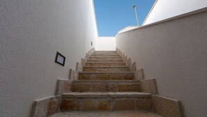 A staircase leading upwards in a building with white walls and a clear blue sky above. - Le Dimore Turchesi (Salve)