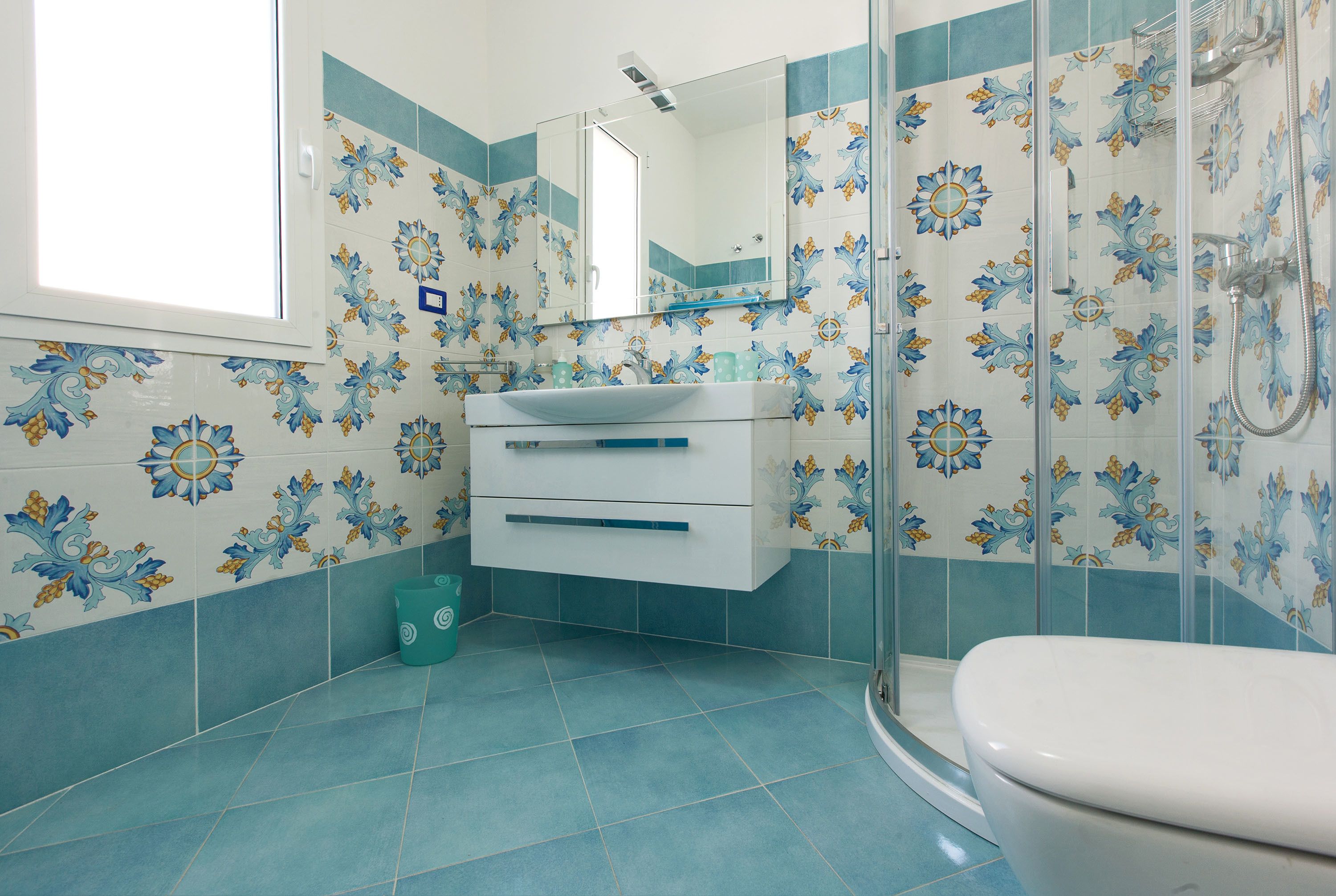 A bathroom with a white sink, a mirror, and a toilet.
