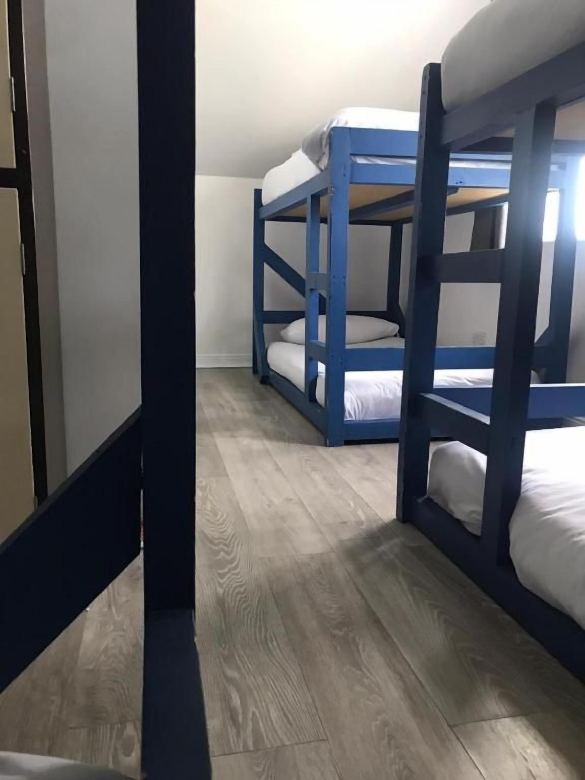 Una stanza con letti a castello, pavimento in legno e stipite.