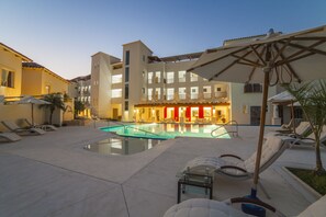 A hotel courtyard with a swimming pool, lounge chairs, and umbrellas. - Mansiones Cruz del Mar Huatulco (Santa María Huatulco)
