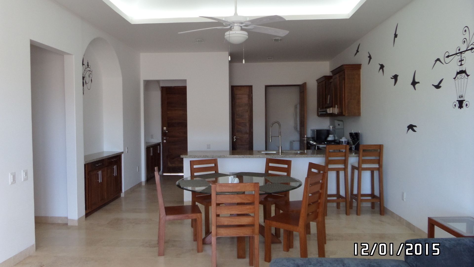 Una cucina moderna con isola centrale, sedie in legno e un tavolo da pranzo.