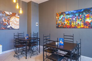 Enjoy meals in this stylish dining area with a large cityscape painting and comfortable seating for four.