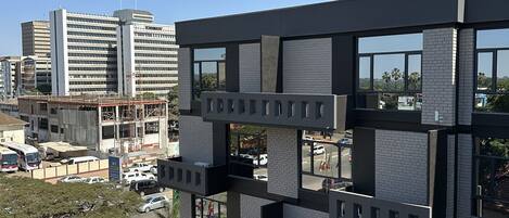 Un edificio moderno con varios pisos, grandes ventanales y una combinación de ladrillo y concreto.