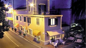 A two-story building with a balcony, outdoor seating area, and a covered entrance. - Hotel Savoia (Ospedaletti)