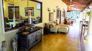Un espacio habitable amplio con un gran ventanal, un conjunto de sofás, una mesa de centro y un aparador decorativo.