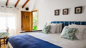 Un dormitorio con una cama grande, una puerta de madera y una ventana con cortinas.