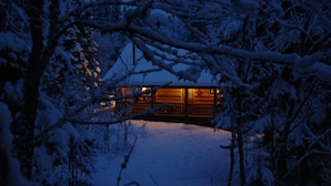 A snow-covered landscape with a wooden cabin. - Cascade Lodge (Lutsen)