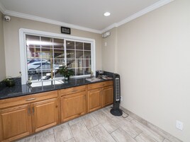 Una cocina con armarios de madera, encimera de granito y ventana con vista a un estacionamiento.