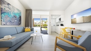 A modern living room with a sofa, a dining table, and a kitchen area. - Relaxia Los Girasoles (San Bartolomé de Tirajana)