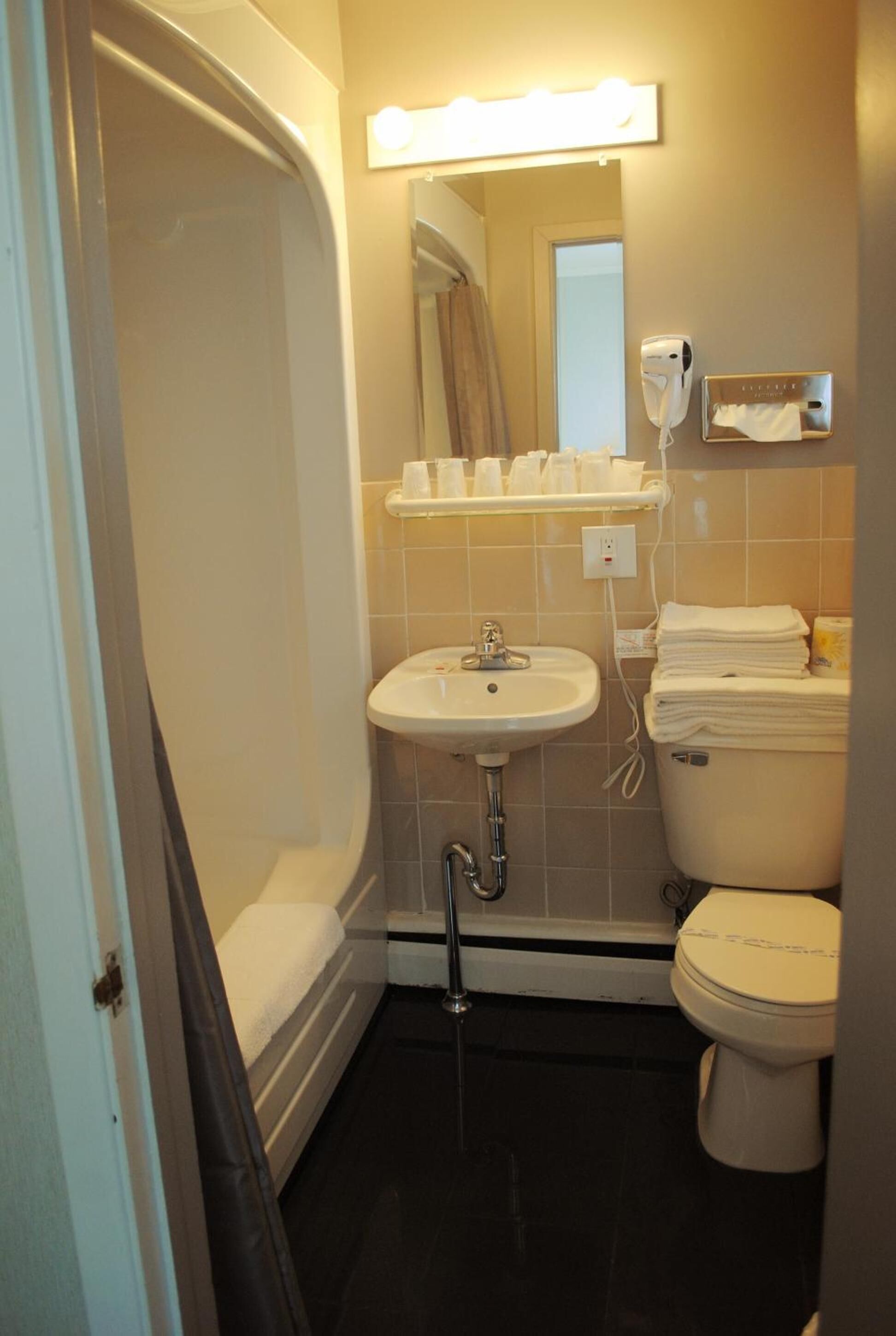 Un baño con bañera, lavamanos e inodoro.