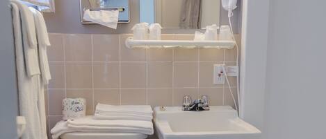 Une petite salle de bain comprenant des toilettes, un lavabo et un espace douche.